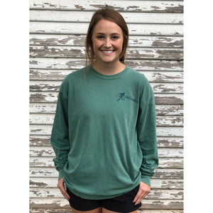 Young woman in green chillwater long sleeve with angler fishing design on the front. Front design features a fly fishing hook on the left chest.