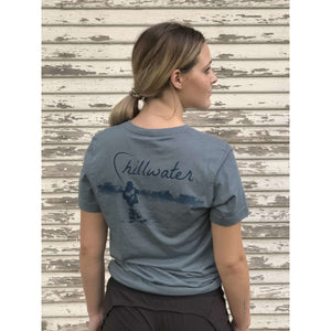Young woman in faded blue chillwater tshirt with angler design on the back. Design features fly fisherman wading in a body of water.