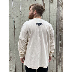 Young male wearing a light ivory long sleeve with the Highlander design by Chillwater. The front resembles a western portrait of a Highlander cow.