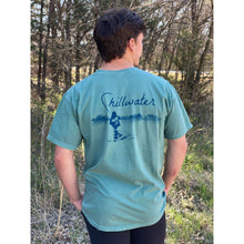 Man wearing green chillwater tshirt with angler design. Design features fly fisherman wading in a body of water.