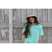 Young woman in a mint green chillwater tshirt with angler design. Front design features a fly fishing hook on the left chest.