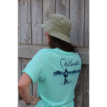 Young girl in a mint green chillwater tshirt with angler design. Design features fly fisherman wading in a body of water.