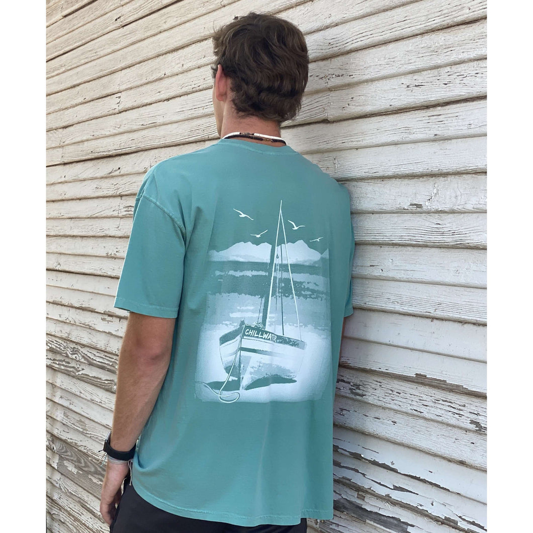 Short sleeve tshirt with chillwater beach bound design on the back. Design is a white sailboat resting on a beach with ocean scene in background.