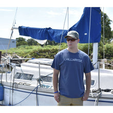Man in short sleeve blue t-shirt featuring the chillwater logo on the front and beach bound design on the back.