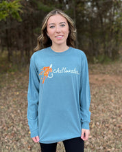 Young female wearing a cornflower blue long sleeve tee Hook and Fly design by Chillwater. The front resembles a fishing hook and fly with Chillwater written across.