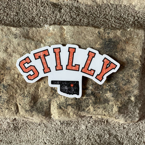 Chillwater Apparel's Stilly design as a sticker with the words in orange and the state of Oklahoma in Black