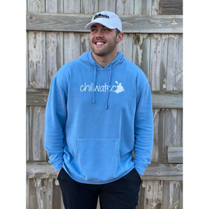 Young male wearing a soothing blue sweatshirt hoodie with the Kayak design by Chillwater. The back resembles a kayaker floating down a river covered by trees.