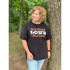 Black unisex short sleeve t-shirt with "Old Folks Love the Pokes" centered on the chest in orange and white lettering.