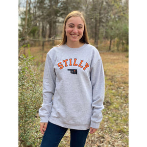 Grey heavy sweatshirt with chillwater's stilly logo in orange and black lettering. Also in the logo is a small black oklahoma icon with an orange star over the stillwater location.