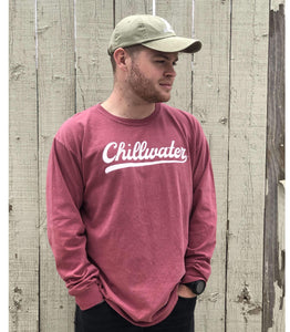 Man wearing red chillwater long sleeve with vintage chill design. Design is in a white script font on the front center. 