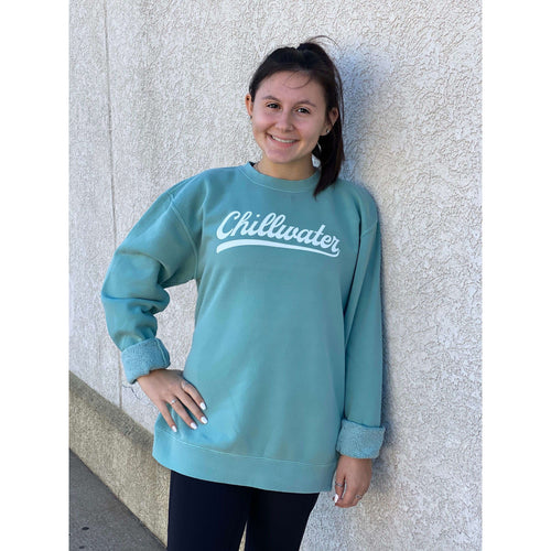Girl wearing a teal chillwater sweatshirt with vintage chill design. Design is in a white script font on the front center.